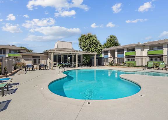 our apartments have a large swimming pool and a patio with chairs